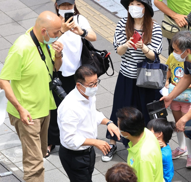 候補者の応援演説に駆け付け、有権者と触れ合う日本維新の会松井一郎代表（手前左）＝６月２６日、尼崎市内