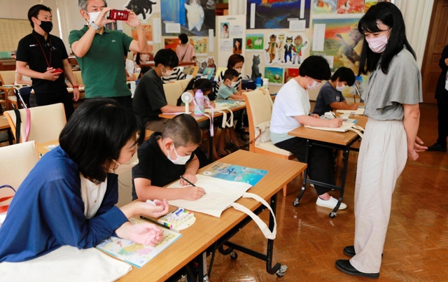 かのうかりんさん（右）からコツを教わりながら、エコバッグにマルを描く子どもら＝神戸市灘区王子町３
