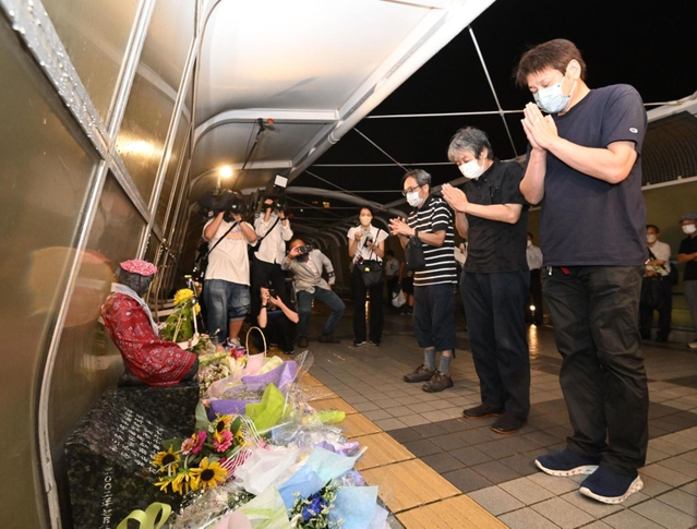 発生から２１年となった歩道橋事故の現場で手を合わせる遺族＝２１日夜、明石市大蔵海岸通１（撮影・坂井萌香）