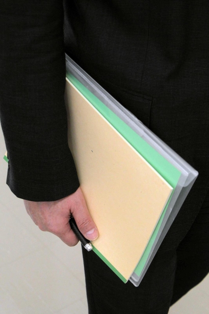 非行内容に関するファイルとノートを手に、家裁調査官は少年との面接に臨む