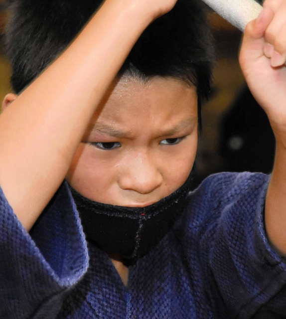 額に汗をにじませながら、鋭いまなざしで素振りをする子ども＝加古川市西神吉町宮前、印南剣道場