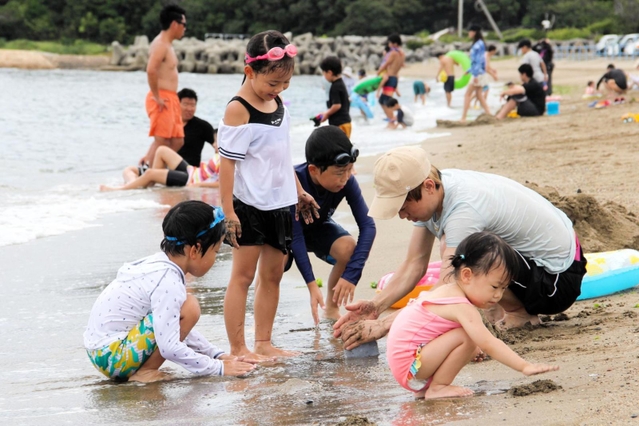 波打ち際で砂遊びを楽しむ家族連れ＝姫路市的形町的形