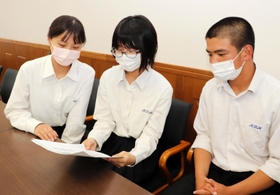 谷川方面から加古川線で通う西脇工業高校の生徒たち。路線の赤字公表を伝える記事に目を通す＝西脇市野村町