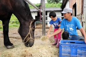 次女帆菜海ちゃんと餌やりをする山下勉さんさん＝洲本市五色町都志大日