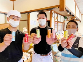 スティック羊羹を手にする衣川政典社長（中央）と妻佳子さん、弟隆文さん＝衣川松陽堂