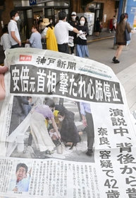 安倍晋三元首相の銃撃事件を知らせる神戸新聞の号外＝８日午後３時２１分、神戸市中央区、ＪＲ神戸駅前（撮影・秋山亮太）