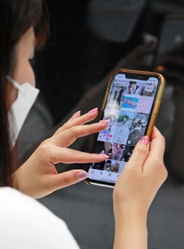 スマートフォンで交流サイト（ＳＮＳ）を眺める若者＝神戸市内