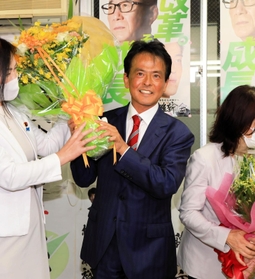 当選確実の報を受けて、花束を受け取る日本維新の会の片山大介氏（中央）＝１０日午後８時９分、神戸市中央区加納町４（撮影・鈴木雅之）