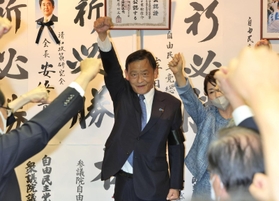 ４選確実の一報が届き、支持者と拳を突き上げる末松信介氏＝１０日午後８時２５分、神戸市中央区元町通１（撮影・小林良多）