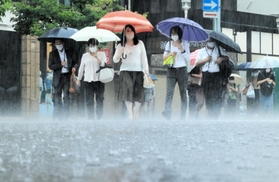 たたきつけるような雨の中を歩く人たち＝１２日午前、神戸市中央区（撮影・鈴木雅之）