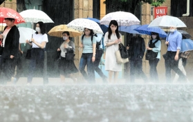 たたきつけるような雨の中を歩く人たち＝１２日午前、神戸市中央区（撮影・鈴木雅之）