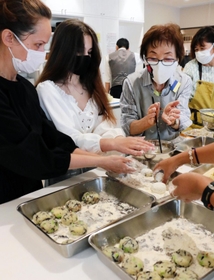 ウクライナからの避難民に、日本食の作り方を教える「プラス１（ＯＮＥ）ネット」のメンバー（右２人）＝神戸市長田区二葉町５