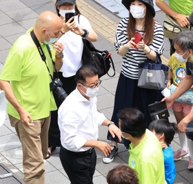 候補者の応援演説に駆け付け、有権者と触れ合う日本維新の会松井一郎代表（手前左）＝６月２６日、尼崎市内