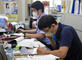 投票所からの速報値をスマホで受ける職員ら＝１０日午前１０時半、猪名川町役場