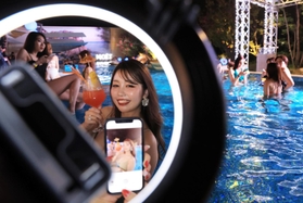 夜のプールで思い思いに写真を撮る人たち＝神戸市中央区新港町