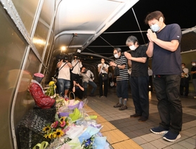 発生から２１年となった歩道橋事故の現場で手を合わせる遺族＝２１日夜、明石市大蔵海岸通１（撮影・坂井萌香）
