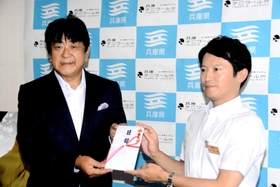 寄付の目録を斎藤元彦知事（右）に手渡す佐渡裕さん＝兵庫県庁