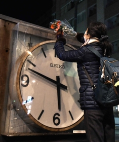 地震発生時間で停止した時計に花を供える近隣住民＝１７日午前５時３５分、西宮市田中町（撮影・三津山朋彦）