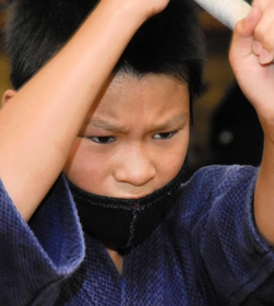 額に汗をにじませながら、鋭いまなざしで素振りをする子ども＝加古川市西神吉町宮前、印南剣道場