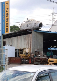 倉庫の屋根にぽつりと置かれた戦闘機＝兵庫県加古川市八幡町