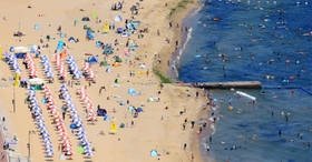 須磨海岸の砂浜には、カラフルなテントやパラソルが並んだ＝３１日午後、神戸市須磨区
