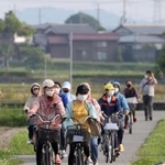 終業時刻とともに職場を後にする外国人労働者ら。車ばかりが通る街にひととき、自転車の車列が現れる＝加東市内