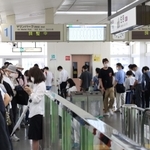 調整中の案内が表示されたホームで車両の到着を待つ乗客ら＝５日午前１０時、神戸市東灘区、六甲ライナー住吉駅（撮影・長嶺麻子）