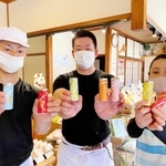 スティック羊羹を手にする衣川政典社長（中央）と妻佳子さん、弟隆文さん＝衣川松陽堂