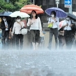 たたきつけるような雨の中を歩く人たち＝１２日午前、神戸市中央区（撮影・鈴木雅之）