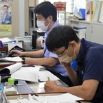 投票所からの速報値をスマホで受ける職員ら＝１０日午前１０時半、猪名川町役場