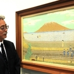 山下清の貼り絵「桜島」（１９５４年）を見つめる山下浩さん＝神戸ファッション美術館