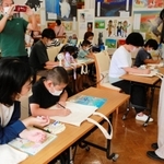 かのうかりんさん（右）からコツを教わりながら、エコバッグにマルを描く子どもら＝神戸市灘区王子町３