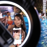 夜のプールで思い思いに写真を撮る人たち＝神戸市中央区新港町