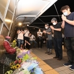 発生から２１年となった歩道橋事故の現場で手を合わせる遺族＝２１日夜、明石市大蔵海岸通１（撮影・坂井萌香）