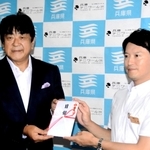 寄付の目録を斎藤元彦知事（右）に手渡す佐渡裕さん＝兵庫県庁