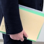 非行内容に関するファイルとノートを手に、家裁調査官は少年との面接に臨む