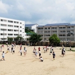 舞多聞小の隣の公園（手前）で休み時間に遊ぶ児童たち。左側の建物が暫定校舎＝神戸市垂水区舞多聞西５