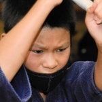 額に汗をにじませながら、鋭いまなざしで素振りをする子ども＝加古川市西神吉町宮前、印南剣道場