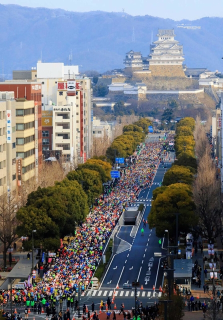 姫路城を背に一斉にスタートするランナーたち＝２０１９年２月、姫路市内