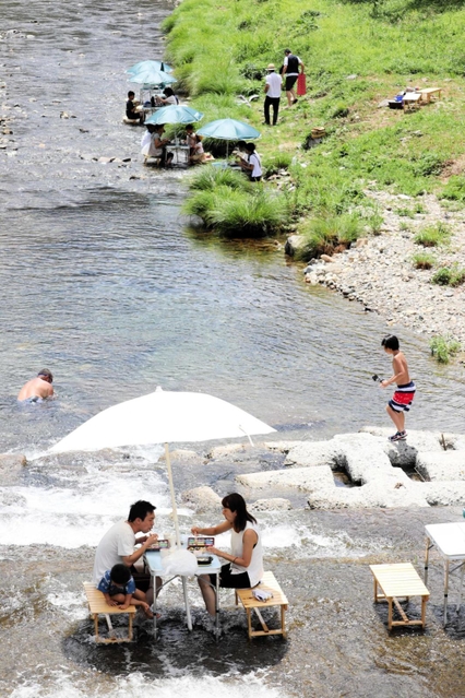 夢前川に足首まで漬かりながら食事を楽しむ家族連れら＝姫路市夢前町山之内