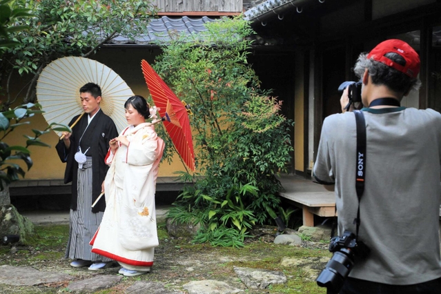 「旧難波酒造」の庭でポーズをとる吉川さん夫妻＝神河町中村