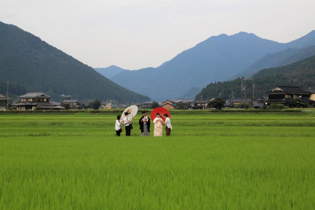田園の真ん中で写真撮影の準備をする吉川さん夫妻とスタッフ＝神河町中村