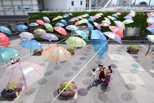 太陽の光を受け色とりどりの傘の色が地面に。記念撮影をする人でにぎわった＝淡路市夢舞台、明石海峡公園（撮影・坂井萌香）
