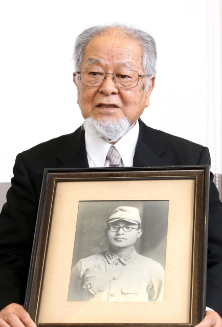 父三郎さんの遺影を抱いて語る三木英一さん＝姫路市本町（撮影・辰巳直之）