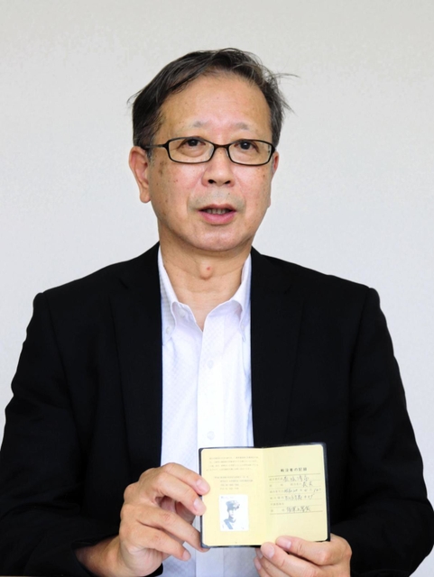 祖父の記録を手に「祖父や多くの人の無念を風化させたくない」と話す荒堀修一さん＝神戸市中央区