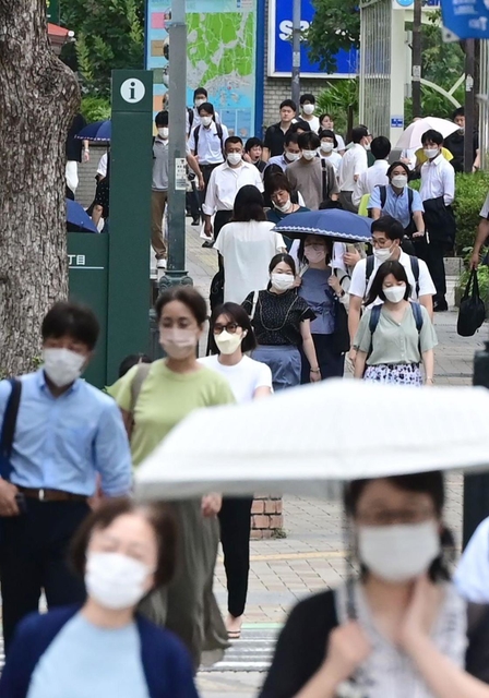 盆が明け、厳しい残暑の中、出勤する人たち＝１６日朝、神戸市中央区