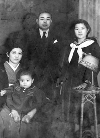 嘉数さん一家。中央が父の昇さん、左が母の千代子さんと幼少時代の昇明さん、右が姉