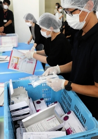 袋詰めした抗原検査キットを検品するスタッフ＝５日午前、明石市本町１