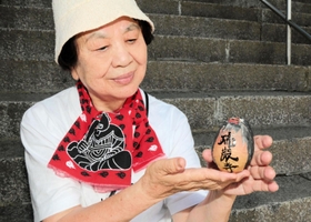 太平洋戦争でソ連軍が侵入した樺太で、いとこ２人を亡くした高濱光永さん。僧侶を表現したマトリョーシカを作った。「敵も味方もない」と平和を祈る＝神戸市兵庫区上祇園町、祇園神社