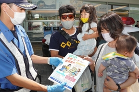 神戸淡路鳴門自動車道の淡路サービスエリアで利用客に安全運転を呼びかける警察官（左）＝淡路市岩屋